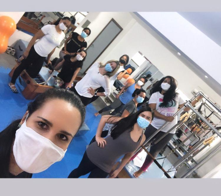 Aula em grupo com gestantes praticando Pilates